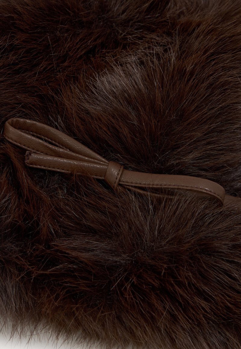 Producto de pelo sintético marrón con una textura suave y esponjosa. Incluye un detalle de lazo de cuero marrón oscuro, que complementa el diseño general.