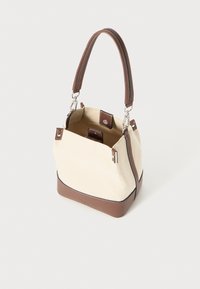 Lærveske med en beige kropp og brune skinnaccentueringer. Har et kort skinnhåndtak og sølvfargede detaljer med en strukturert form.