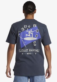 Navy blue cotton t-shirt featuring graphic print on back, including a blue triangle, abstract figure, and text "LIQUID RHYTHM."