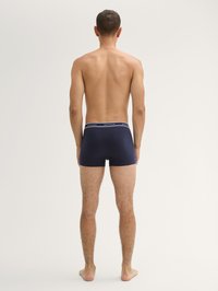 Sötétkék boxer alsó, kontrasztos szürke derékrésszel, puha anyagból készült. A design szoros illeszkedést és minimális varrásokat jellemző.