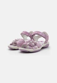 Lila Sandalen mit floralem Muster, verstellbaren Klettverschlüssen, strukturiertem Obermaterial und einer weichen Sohle, die lila Punkte für besseren Halt bietet.