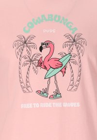 Vaaleanpunainen t-paita, jossa on sarjakuvamainen flamingo aurinkolasit päässään, surffilauta käsissään, palmut ympärillä, ja tekstit "COWABUNGA DUDE" ja "VAPAA AALTOJEN KYYDITETTÄVÄ."