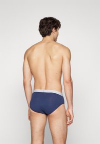 Dunkelblaue Baumwoll-Boxershorts mit einem grauen elastischen Bund. Das Material wirkt glatt, eng anliegend und hat minimale sichtbare Nähte.