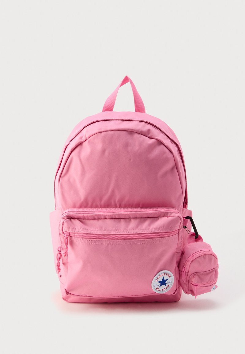 Zaino rosa realizzato in tessuto resistente, dotato di un ampio compartimento principale, una tasca frontale con cerniera e una tasca laterale. Include una targhetta con logo.