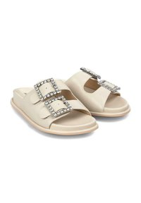 I sandali scivolosi beige presentano due ampie cinghie con fibbie quadrate in strass, una finitura in pelle liscia e una suola piatta in gomma.