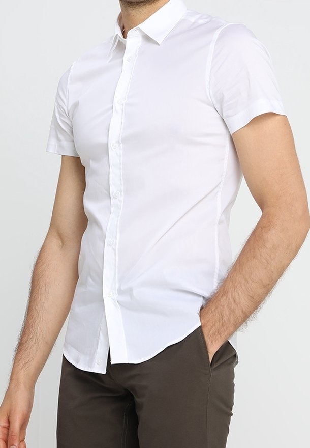 Vit kortärmad skjorta med knapp i en spetsig krage, tillverkad av en slät tyg, med slim fit och rak nederkant.