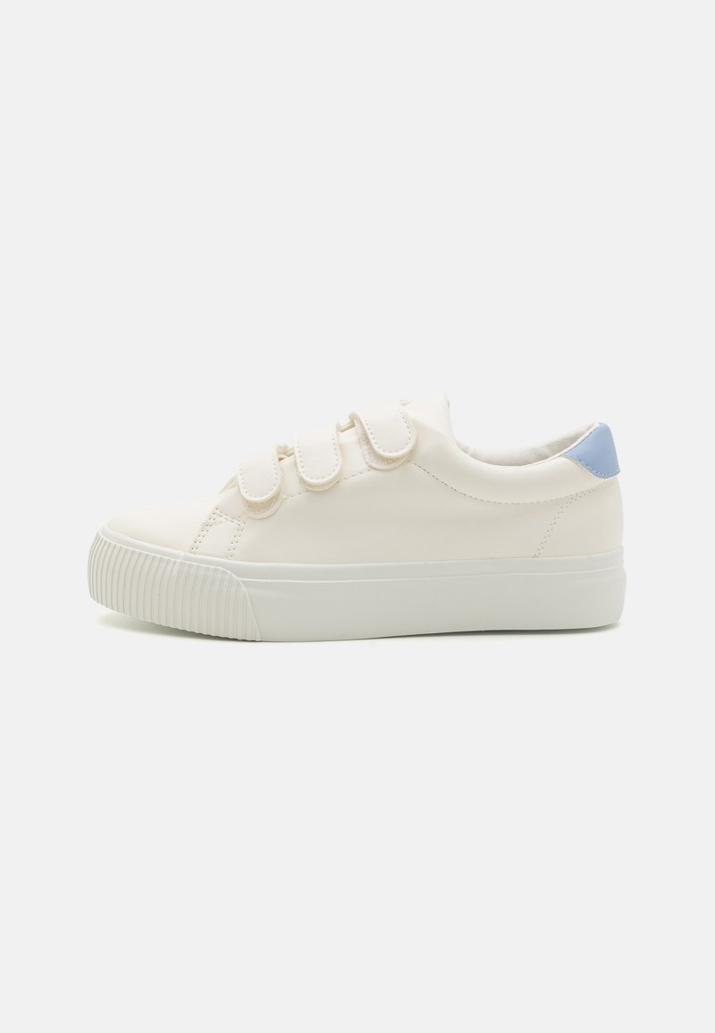 White sneaker with hook-and-loop straps, smooth texture, slightly raised rubber sole, and a light blue accent at the heel.