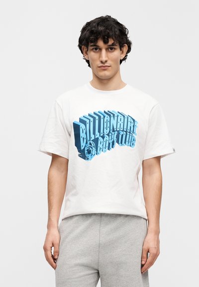 Λευκό βαμβακερό μπλουζάκι με κοντά μανίκια, διακοσμημένο με μπλε γραφικό κείμενο "Billionaire Boy Club." Ο σχεδιασμός περιλαμβάνει γράμματα σε 3D στιλ.