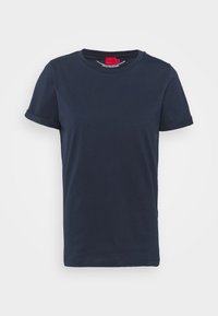 Marinblå t-shirt i bomull med korta, rullade ärmar, rund halsringning och en enkel design. Har en röd etikett på den inre halsringningen.