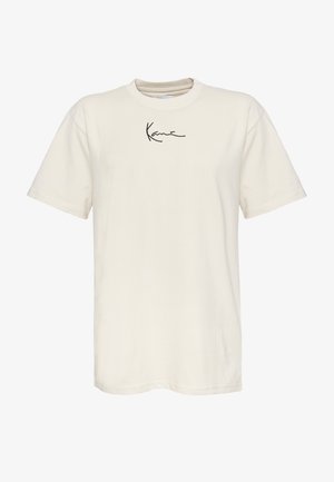 Krem majica od pamuka s kratkim rukavima, okruglim izrezom i malim crnim potpisom na lijevoj strani prsa. Glatka tekstura, običan kroj.