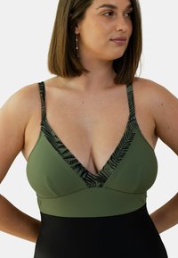 Maillot de bain vert olive avec un décolleté en V plongeant et une finition à motifs noirs. Dispose de bretelles réglables et d'une coupe ajustée. Texture lisse dans l'ensemble.