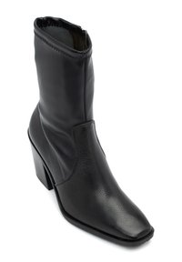 Czarne skórzane botki za kostkę z kwadratowym noskiem, teksturowaną powierzchnią i wypukłym przeszyciem. Posiadają blokowy obcas oraz zamek błyskawiczny z boku, co ułatwia zakładanie.