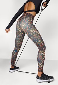 Legginsy wysokie w talii z kolorowym, abstrakcyjnym wzorem. Wykonane z elastycznego materiału, z gładką teksturą i oddychającymi akcentami z siateczki.