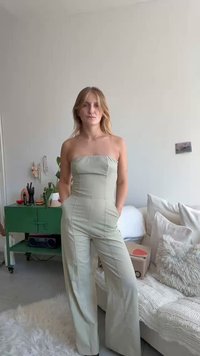 Strapless jumpsuit van lichtgroene stof, met een aansluitende lijfje en wijde pijpen. Glad textuur met verticale naden en zijzakken.