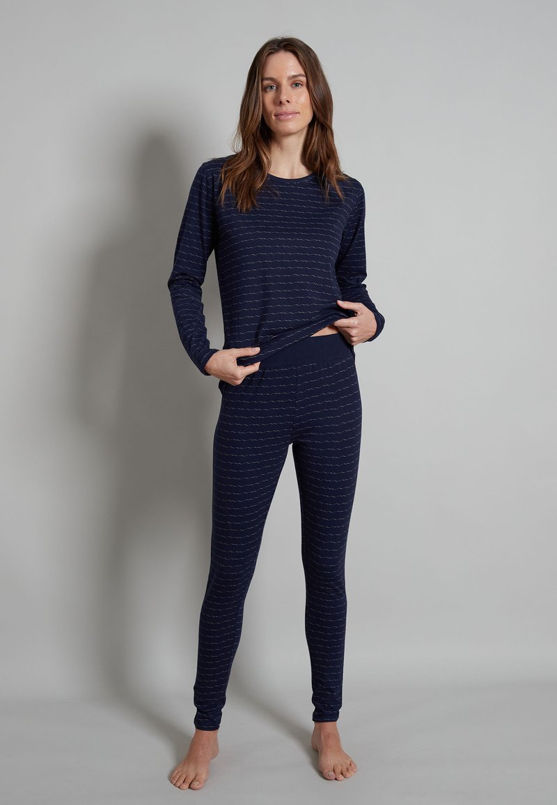 Completo di maglietta a maniche lunghe e leggings di colore blu navy, realizzato in materiale morbido con un motivo ondulato di tonalità più chiara. Caratterizzato da una vestibilità aderente e vita elastica.