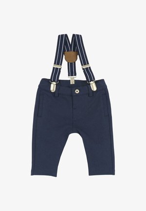 Pantalon bébé bleu marine avec poches avant et bouton, associé à des bretelles rayées bleues et blanches fixées par des clips argentés et un patch en cuir marron.