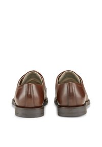 Scarpe in pelle marrone dal design elegante, con punta arrotondata e tacco basso. Presentano dettagli di cucitura e una finitura liscia.