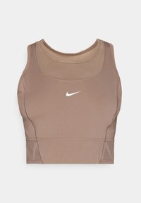 Reggiseno sportivo marrone realizzato in materiale elasticizzato con scollatura arrotondata. Presenta un logo Nike bianco sul davanti e un dettaglio testurizzato in basso.