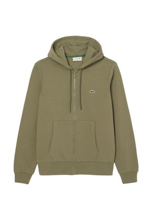 Felpa con zip verde oliva realizzata in tessuto morbido, con una tasca a marsupio e un piccolo logo Lacoste sul lato sinistro del petto.