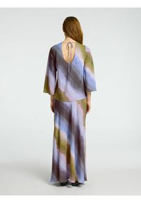 Maxikleid aus fließendem Stoff mit einem mehrfarbigen, abstrakten Muster in Blau-, Grün- und Brauntönen. Mit einem Rückenausschnitt und einer Bindung.