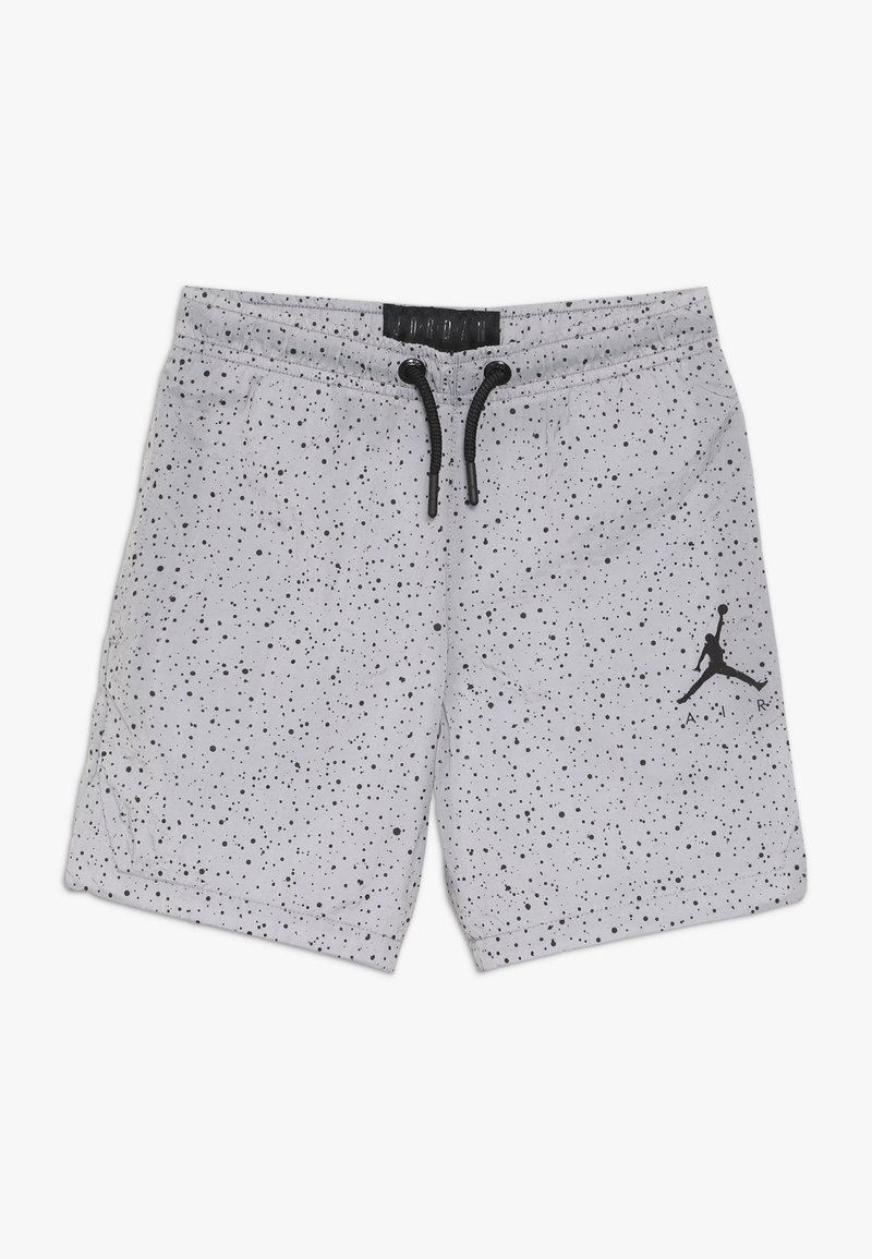 Short de sport gris clair avec motif tacheté noir, cordon noir, poches latérales et logo Air Jordan noir sur la jambe droite.