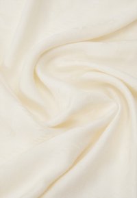 Tkana tkanina w delikatnym kremowym kolorze, z subtelnym wzorem teksturowym i gładkim opadaniem, idealna do różnych zastosowań tekstylnych.