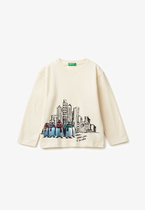 Krémová košile s dlouhým rukávem a kreslenými tučňáky ve šále a grafikou městské krajiny. Měkký bavlněný materiál, kulatý výstřih, volný střih.