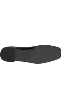 Scarpa in vernice nera con superficie liscia, punta leggermente affusolata e suola in gomma testurizzata bassa. Logo del marchio visibile sulla suola.