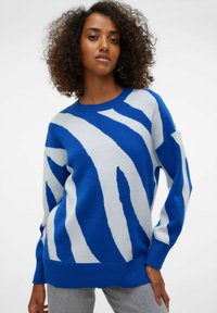 Pull rayé bleu et blanc avec une coupe décontractée, un col rond et des manches longues. Tissu en maille douce avec des motifs audacieux contrastants.