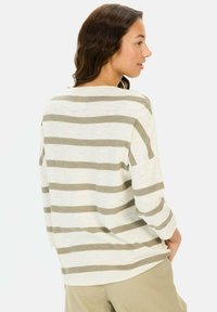 Langärmliges gestreiftes Hemd in hellem Creme und Taupe, lockere Passform, Rundhalsausschnitt, mit einer Tasche auf der linken Seite. Weicher Stoff.