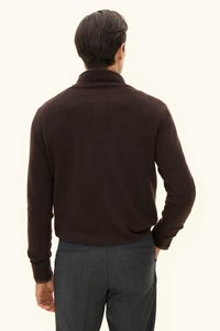 Brauner Strickpullover mit hohem Kragen, langen Ärmeln und gerippten Bündchen. Getragen mit dunkelgrauen, maßgeschneiderten Hosen. Glatte Textur offensichtlich.