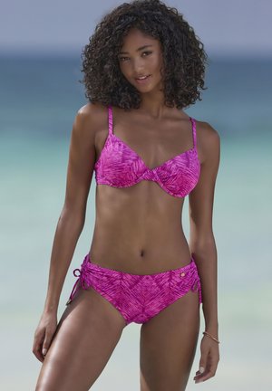 Bikini set in vibrant pink with a textured leaf pattern. Bra has underwire and adjustable straps; bottoms feature side ties and a lined design.