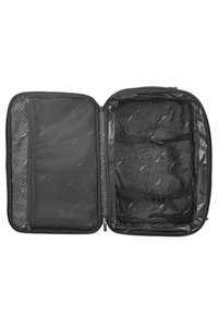 Bolsa de viaje negra sin cerrar, con un bolsillo de malla y correas interiores sobre un forro estampado. Material exterior texturizado y diseño elegante.