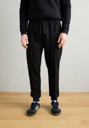 CARROT FIT IN INTERLOCK BLEND WITH LOGOED BADGE - Tracksuit bottoms - black