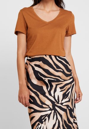 Brązowy T-shirt z dekoltem w serek połączony z dopasowaną spódnicą w czarno-beżowy wzór zwierzęcy. Miękka tkanina, krótkie rękawy i smukła sylwetka.