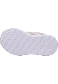 Semelle de chaussure de sport grise avec un fond en caoutchouc blanc texturé, présentant un motif en chevrons. Des accents rose clair sont visibles.