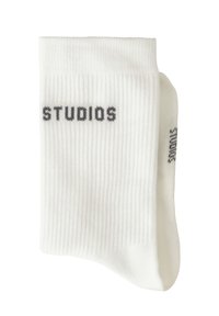 Weiße gerippte Socken mit dem Schriftzug "STUDIOS" in Grau. Verfügen über eine Standardform und -textur, geeignet für den Freizeitgebrauch.