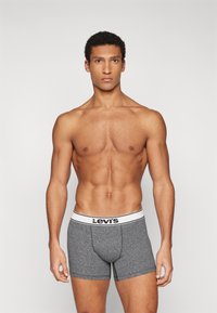 Γκρι βαμβακερά boxer briefs με λευκή ζώνη που φέρει το λογότυπο της Levi's. Η εφαρμογή είναι στενή και το ύφασμα έχει λεία υφή.