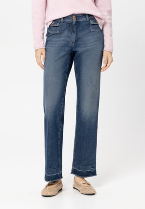 Wide-leg denim jeans in dark blue with a faded finish, featuring front pockets and raw hem details, paired with light-colored shoes.