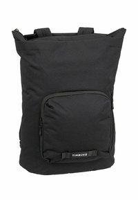 Mochila negra con un compartimento principal con cremallera, bolsillo frontal, tejido texturizado, asas acolchadas y un parche con el logo en la parte inferior delantera.