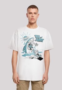 White cotton t-shirt featuring a blue and black cartoon design of a shark and characters from Tom and Jerry. Relaxed fit, short sleeves.