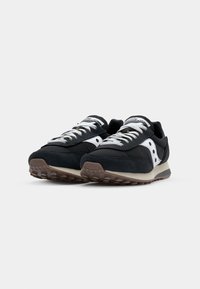 Black sneakers with suede and mesh materials, featuring white accents, round laces, and textured rubber soles. Classic retro design.