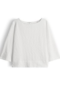 White knit sweater with vertical ribbed texture, three-quarter bell sleeves, and a round neckline.