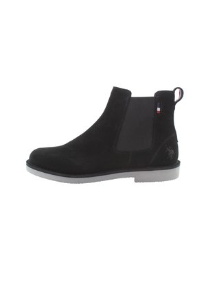 Bota Chelsea de ante negra hasta el tobillo con paneles laterales elásticos y una lengüeta. Presenta una suela de goma gris y un pequeño detalle de logotipo en el talón.