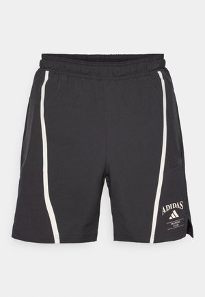 Shorts de sport noirs avec une taille élastique, dotés de bandes latérales blanches et d'un logo Adidas sur la jambe inférieure droite.