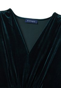 Robe en velours vert avec un décolleté en V profond, des épaules froncées et une étiquette avec "PIOMBO" au niveau du cou. Texture lisse et design drapé.