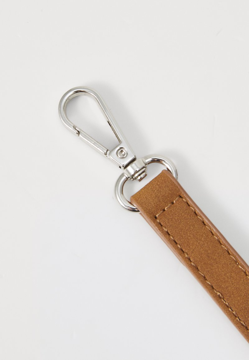 Brązowy skórzany pasek z metalowym klipsem w kolorze srebrnym; pasek ma gładką fakturę i staranne przeszycia.