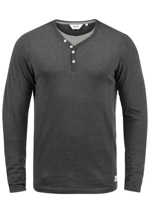 Maglietta henley a maniche lunghe, color grigio scuro, realizzata in un tessuto morbido con scollatura a V, patta con tre bottoni e dettagli di cucitura discreti all'orlo.