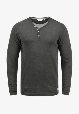 Camisa henley de manga larga en gris oscuro, hecha de tela suave, con escote en V, tapeta de tres botones y sutiles detalles de costura en el dobladillo.