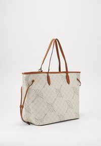 Tote-väska med ett mönstrat creamfärgat ytterlager, bruna läderremmar och kant. Har en strukturerad form och sömdetaljer.